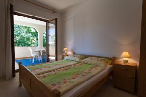 a bedroom with a large bed with a large window at Apartments Draga in Vantačići