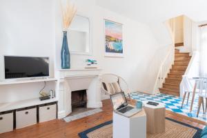 a living room with a fireplace and a laptop on a table at L'Escapade - Maison avec petit jardin - 4 pers in Étretat