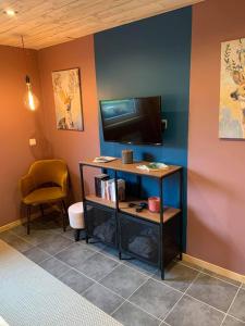 a room with a desk with a television and a chair at Le Soleil Couchant/Chambre d'hôtes in Givet