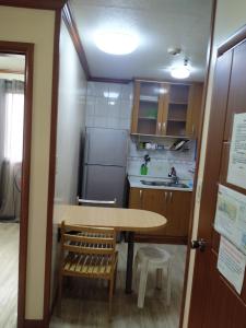 Il comprend une petite cuisine équipée d'une table et d'un réfrigérateur. dans l'établissement Zenmist Properties- 2 Bedroom Economy, à Baguio