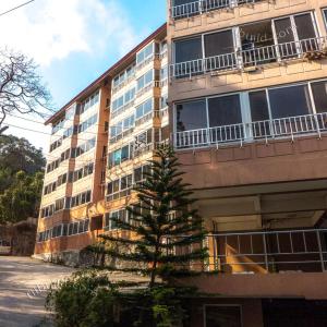 a building with a pine tree in front of it at Zenmist Properties- 2 Bedroom Economy in Baguio
