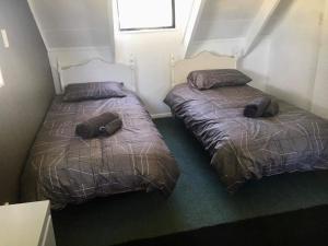 dos camas sentadas una al lado de la otra en un dormitorio en Hirangi cottage, en Turangi