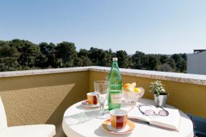 扎達爾的住宿－米里亞娜公寓酒店，阳台上的桌子上放着两杯和一瓶