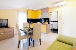 comedor y cocina con mesa y sillas en Apartments Mirjana, en Zadar