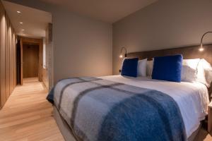 a bedroom with a large bed with blue pillows at Vip Residences Andorra in El Tarter