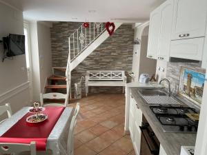 uma cozinha com uma mesa, um lavatório e uma escadaria em La casa di Vesta em Pompeia