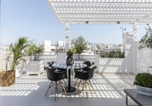 比雷埃夫斯Gallery Suites & Residences Piraeus的屋顶上有桌椅的露台