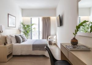 比雷埃夫斯Gallery Suites & Residences Piraeus的一间卧室，配有一张床和一张带椅子的书桌