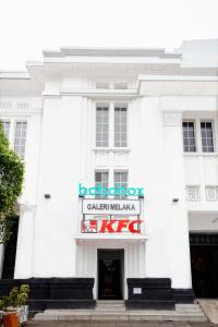 a white building with a sign in front of it at Bobopod Kota Tua, Jakarta in Jakarta