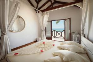 a bedroom with two beds and a window with the ocean at Clef des Iles in Beau Vallon
