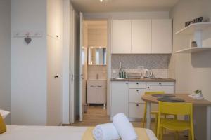 a small kitchen with a table and yellow chairs at Roomies Zagreb in Zagreb