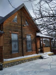 a log cabin with a porch in the snow at Holiday Home Angie in Kolašin