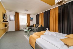 um quarto de hotel com uma cama e um sofá em Topáz Apartmanházak em Balatongyörök