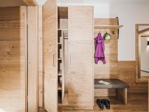 Habitación con armario con un abrigo púrpura colgado en la pared. en Mo's Apartments, en Mayrhofen 73 fotos más
