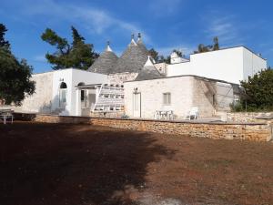 ein großes weißes Gebäude mit einer Treppe davor in der Unterkunft Trullo Amico in Cisternino