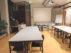 a classroom with tables and chairs and a whiteboard at Hotel Kokkola in Kokkola