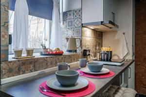 a kitchen with two bowls and plates on a counter at Apartment ALPINE URBAN GARDEN in Saint Petersburg