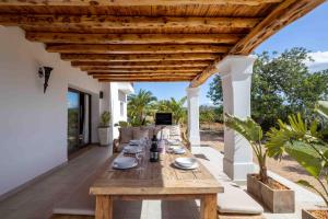 a wooden table on the patio of a house at Villa Can Lloren in Sant Llorenç de Balafia