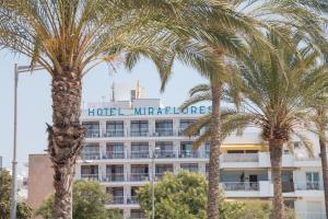 a hotel with palm trees in front of it at Hotel Amic Miraflores in Can Pastilla