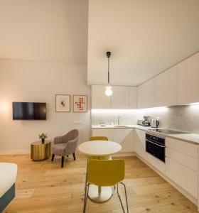 uma cozinha com armários brancos e uma mesa e cadeiras em Lisbon Serviced Apartments - Mouraria em Lisboa