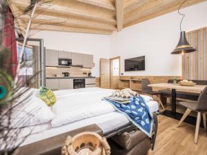 Un dormitorio con una cama grande y una cocina. en Mo's Apartments, en Mayrhofen