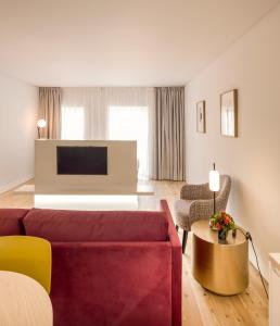 a living room with a red couch and a tv at Lisbon Serviced Apartments - Mouraria in Lisbon