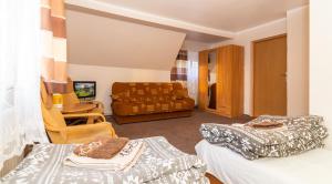 a hotel room with two beds and a couch at Gospoda i Noclegi Na szlaku in Kudowa-Zdrój