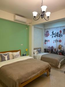 um quarto com 2 camas e uma pintura chinesa na parede em Er Jie's House em Jinning