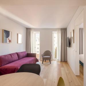 a living room with a purple couch and a table at Lisbon Serviced Apartments - Mouraria in Lisbon +81 photos
