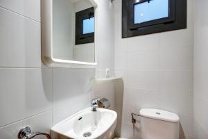 a bathroom with a toilet and a sink and a mirror at Migjorn 2 2 Roses - Immo Barneda in Roses +12 photos