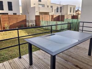 einen Tisch auf einer Holzterrasse in der Unterkunft Coquet pavillon avec jardin et terrasse dans une résidence à 500m de la mer in Sérignan