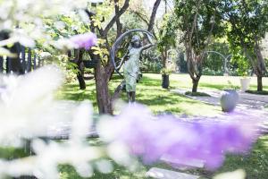 uma estátua de uma mulher ao lado de uma árvore em Burkleigh House em Joanesburgo