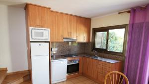 ミアミ・プラトーヤにあるCasas Blancas 37のキッチン(木製キャビネット、白い冷蔵庫付)