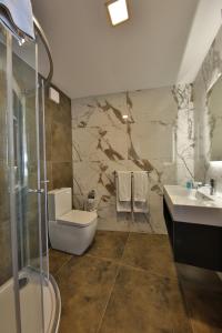 a bathroom with a toilet and a sink and a shower at Ivy Hotel - Adults Only in St. Julianʼs