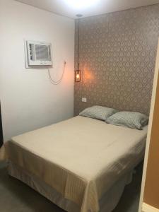 a bedroom with a bed and a air conditioner at Flat Sao Vicente in São Vicente