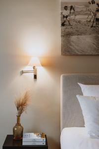 ein Schlafzimmer mit einem Bett und einem Tisch mit einer Lampe in der Unterkunft Grand Hotel Belle Vue in De Haan