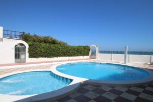 a large swimming pool in a patio with the ocean in the background at Casas Blancas 37 in Miami Platja