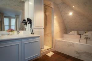 een badkamer met een wastafel, een douche en een bad bij Canalside House - Luxury Guesthouse in Brugge