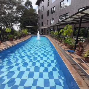 a swimming pool with a fountain in the middle of a building at Park Place Hotel in Nairobi