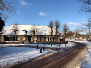 a building in the snow with a road in front at Boutique stay Mir Lo in Mierlo in Mierlo