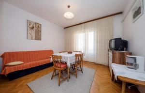 a living room with a table and a couch at Apartment Ante Kampor in Kampor
