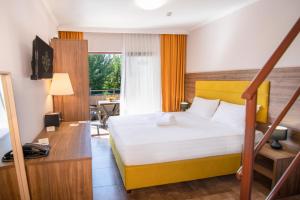 a hotel room with a bed and a desk at Hotel Palladium Sithonia in Kalamitsi
