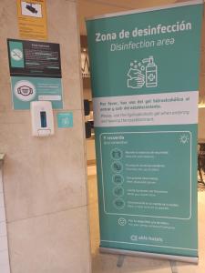 un signe dans un magasin avec un signe pour un établissement de désinfection dans l'établissement Hotel Alda El Suizo, à Ferrol