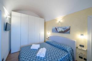 a bedroom with a bed with two towels on it at Holiday House Nuvola in Amalfi Coast in Furore