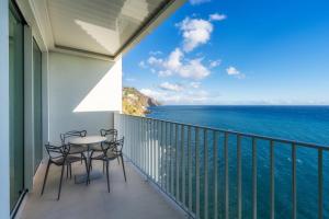 a balcony with chairs and a table and the ocean at Barreirinha Front-Line Sea View II by HR Madeira in Funchal