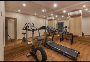 a gym with several exercise bikes and a mirror at Regenta INN Grand Koramangala by Royal Orchid Hotels in Bangalore