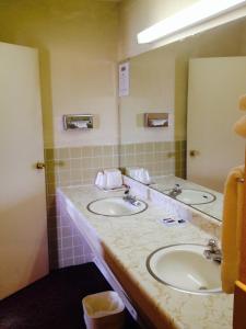 a bathroom with two sinks and a large mirror at America's Best Inn and Suites Emporia in Emporia