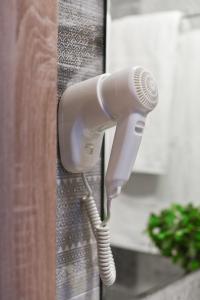 a blow dryer is attached to a shower curtain at Hotel Palladium Sithonia in Kalamitsi