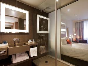 a hotel room with a bed and a mirror at Novotel London Tower Bridge in London