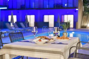 a table with two glasses of wine and food on it at Hotel Palladium Sithonia in Kalamitsi